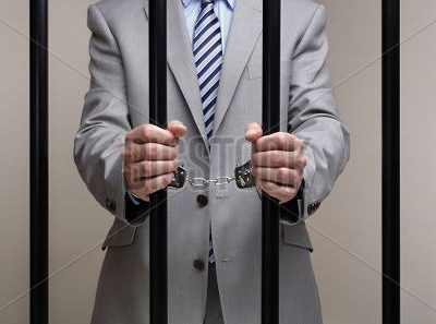 Man in a suit behind prison bars